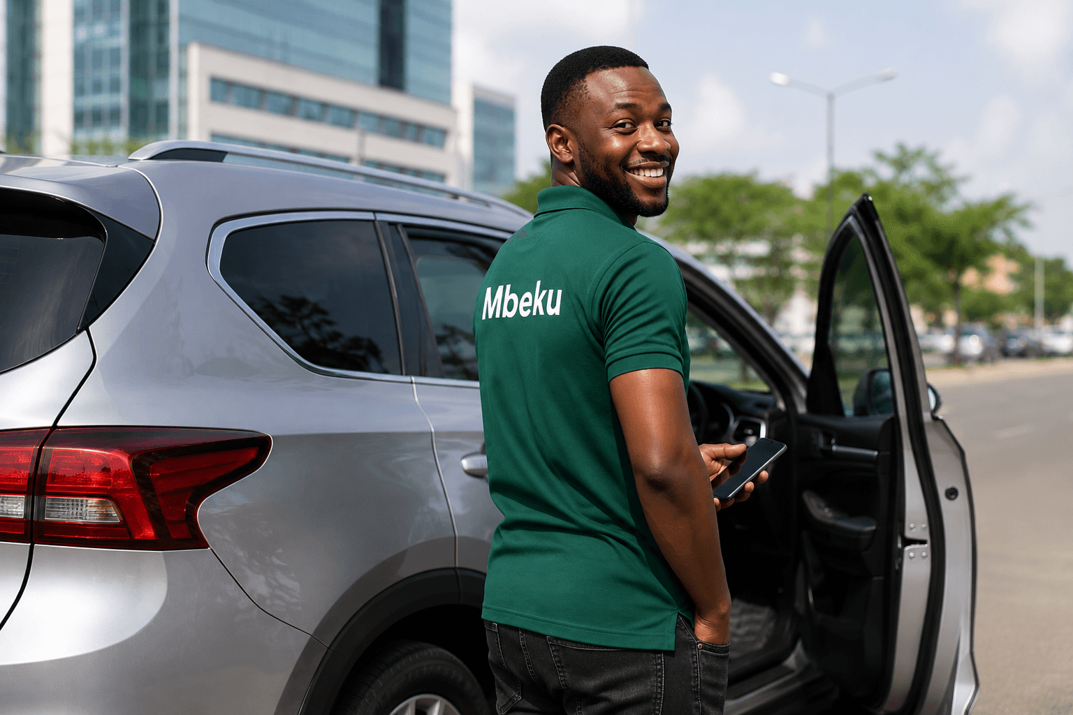 Mbeku driver standing by his car holding a phone